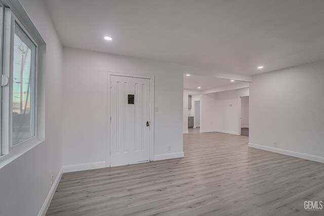 unfurnished room with light wood-type flooring, baseboards, and recessed lighting