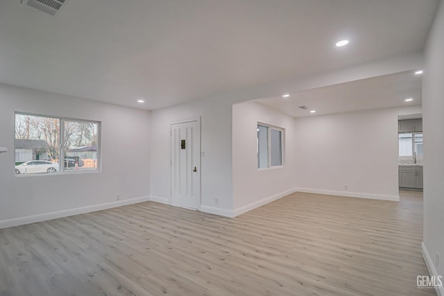 unfurnished room with baseboards, visible vents, and light wood finished floors