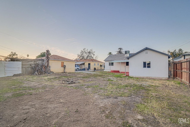 back of house featuring fence and stucco siding