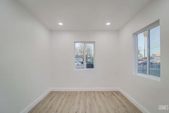 empty room with light wood-style floors, baseboards, and recessed lighting