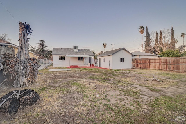 rear view of property with an outbuilding and a fenced backyard