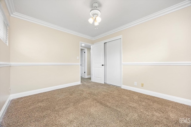 unfurnished bedroom featuring carpet flooring, a closet, ceiling fan, and crown molding