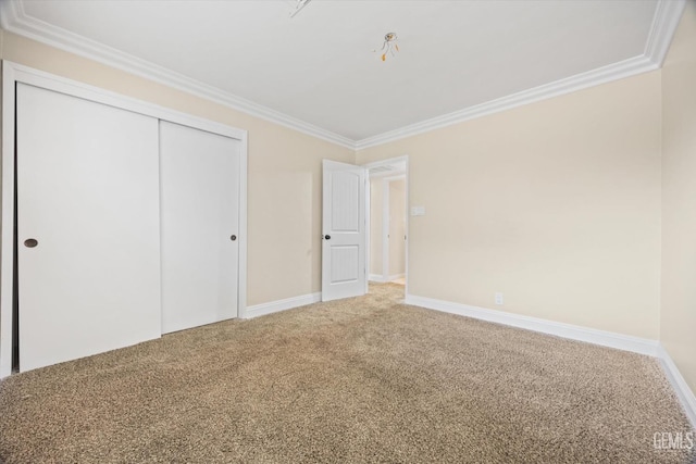 unfurnished bedroom with a closet, carpet floors, and ornamental molding