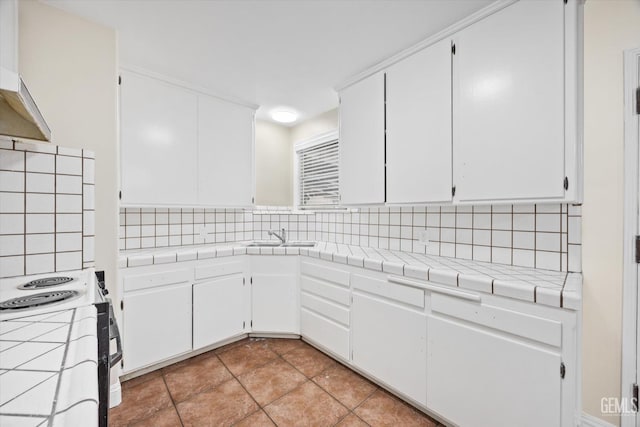 kitchen featuring tile counters and white cabinets