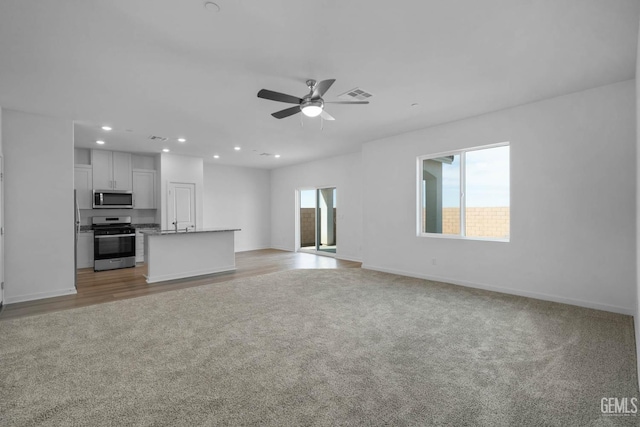 8407 Seth Alexander Way, Bakersfield, CA 93306 - unfurnished living room featuring light colored carpet, ceiling fan, baseboards, and recessed lighting
