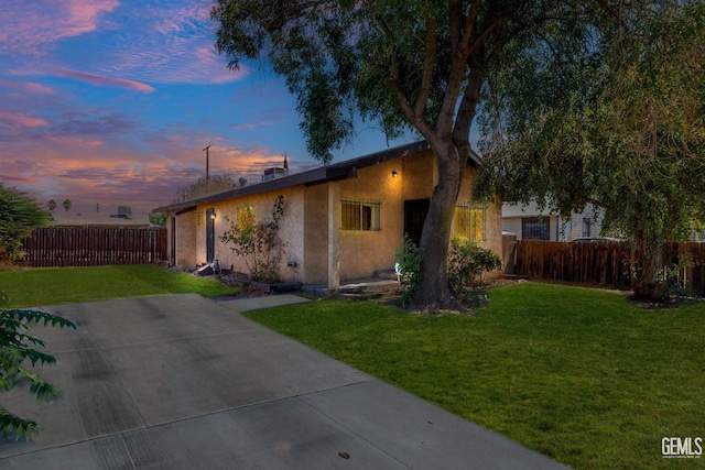 property exterior at dusk with a yard