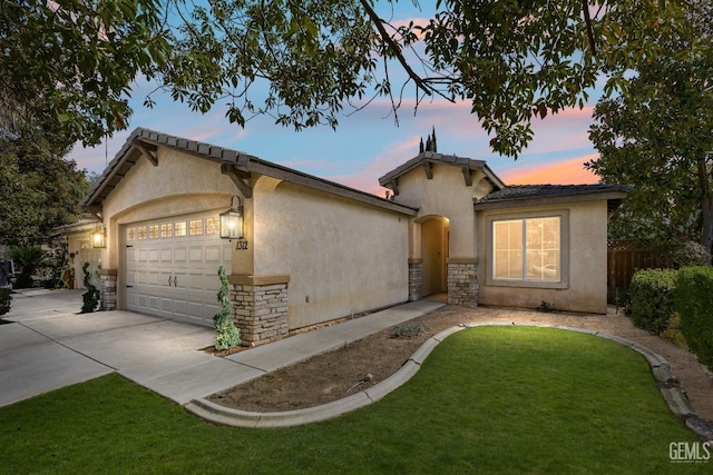 mediterranean / spanish-style house featuring fence, stucco siding, concrete driveway, a garage, and stone siding