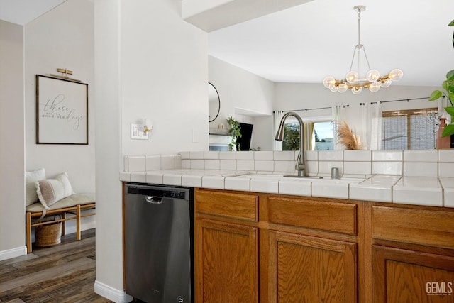 kitchen featuring dark wood finished floors, lofted ceiling, a sink, dishwasher, and brown cabinets