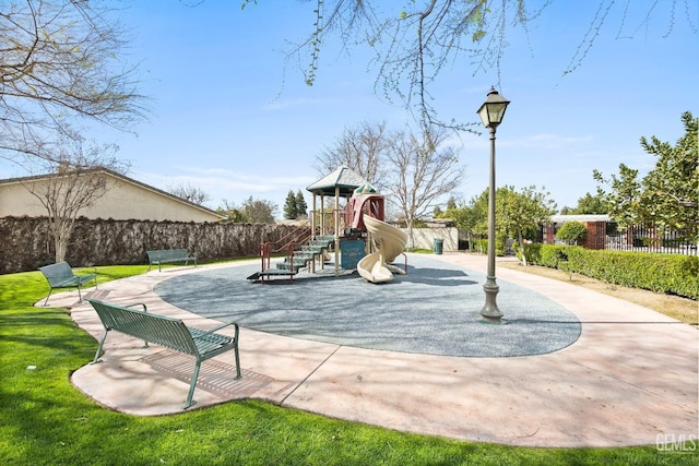 communal playground with a yard and fence