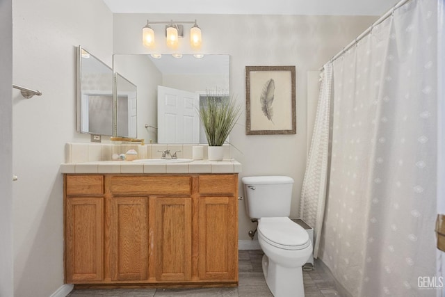 full bathroom featuring vanity, toilet, and baseboards