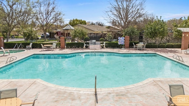 community pool featuring a patio and fence