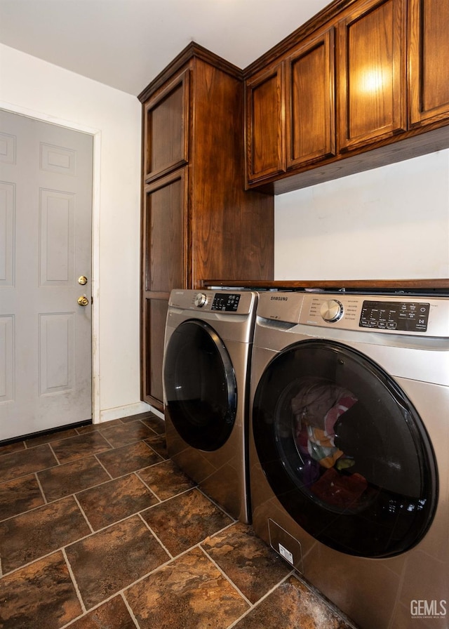 clothes washing area with cabinets and washing machine and dryer