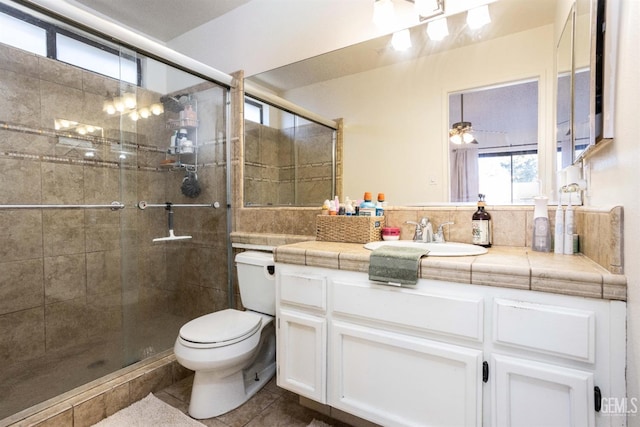 bathroom with a shower with shower door, tile patterned floors, toilet, and vanity