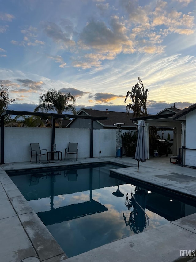 pool at dusk with a patio