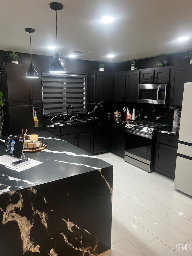 kitchen with pendant lighting, stainless steel appliances, and sink