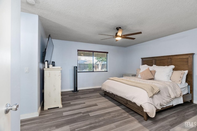 bedroom featuring a ceiling fan, a textured ceiling, baseboards, and wood finished floors