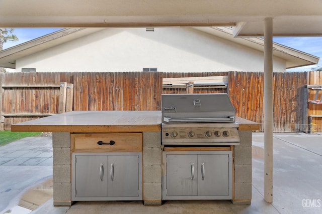 view of patio / terrace with an outdoor kitchen, a grill, and fence