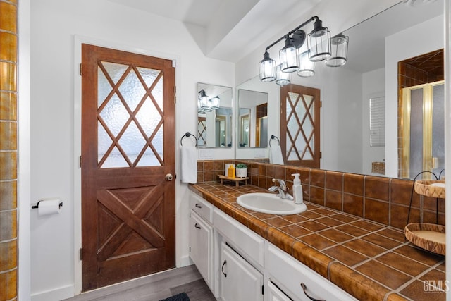 full bath with tasteful backsplash, vanity, wood finished floors, and a shower stall