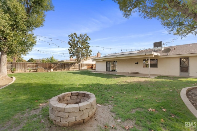 view of yard with an outdoor fire pit, central air condition unit, fence, and a patio