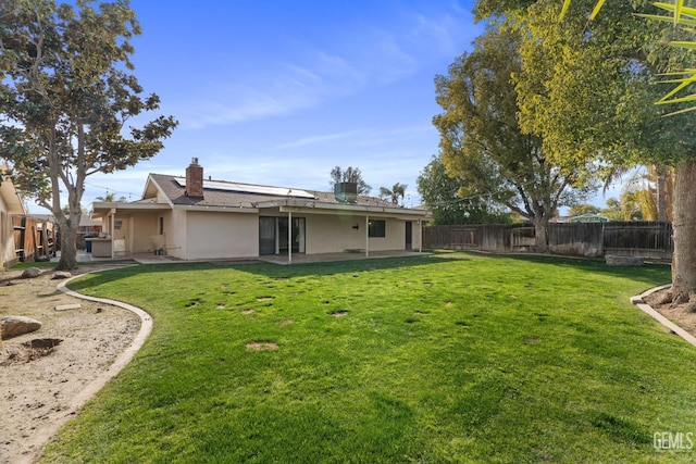 back of house featuring a patio, a lawn, and a fenced backyard