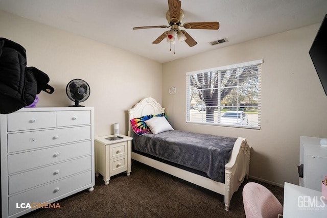 bedroom featuring a ceiling fan, dark colored carpet, visible vents, and baseboards