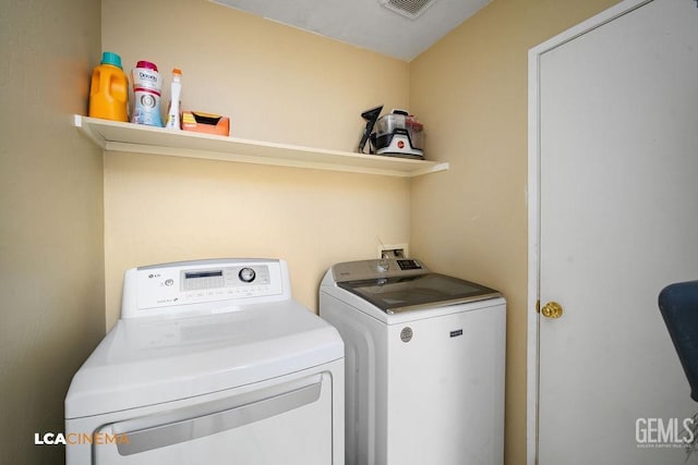 clothes washing area featuring laundry area, visible vents, and washer and dryer