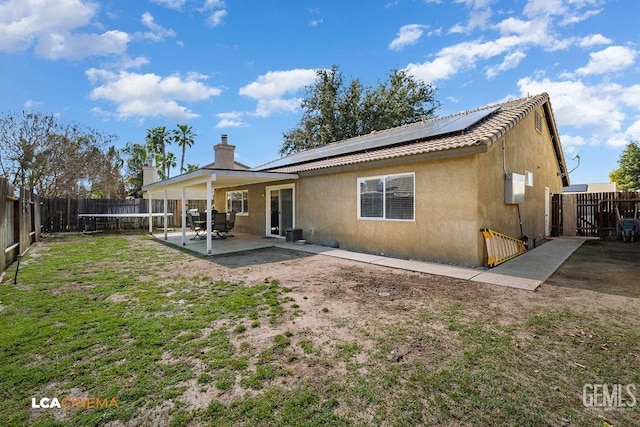 back of property with a patio area, a fenced backyard, solar panels, and stucco siding