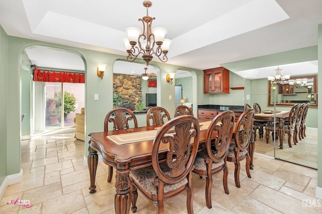 dining room with a raised ceiling and a notable chandelier