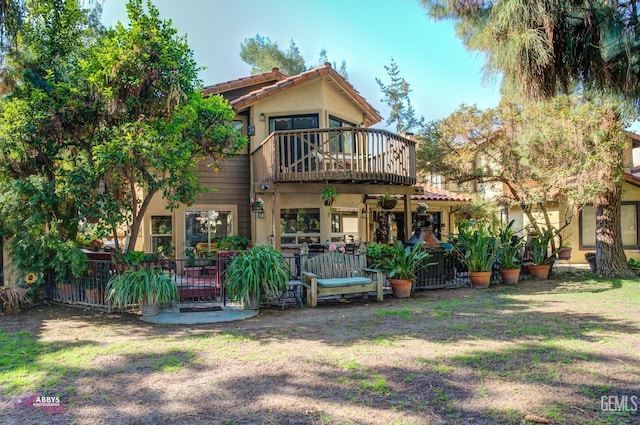 rear view of property with a yard and a deck