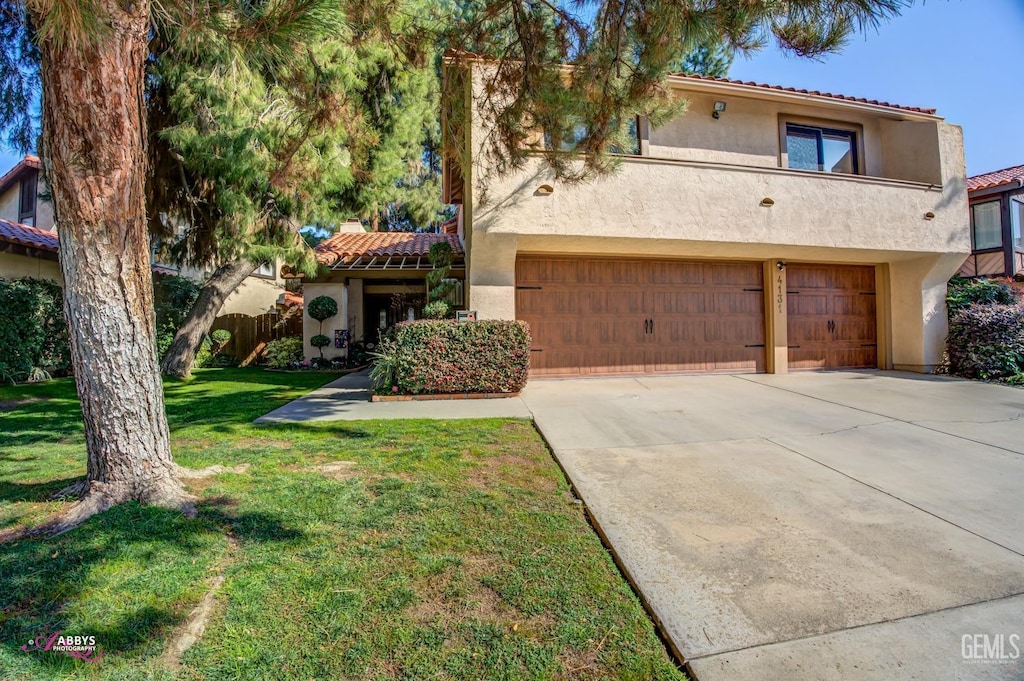 mediterranean / spanish-style home with a garage and a front lawn