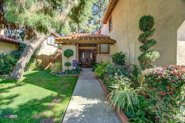 view of exterior entry featuring a yard