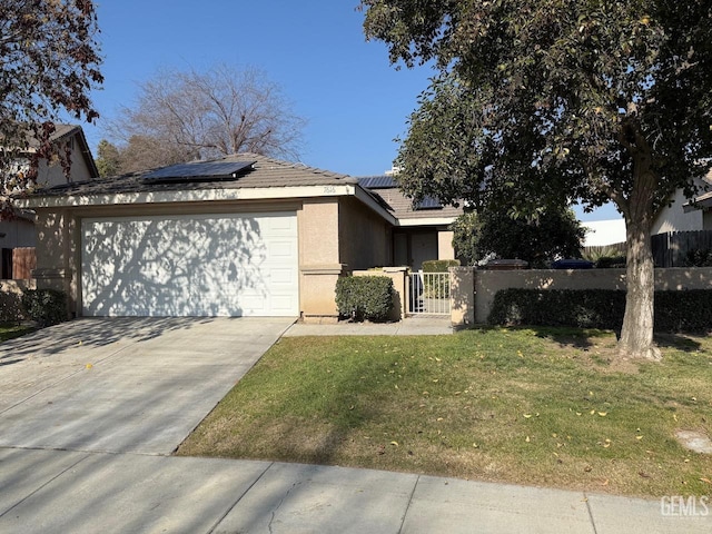 view of front of home featuring a front yard, solar panels, and a garage