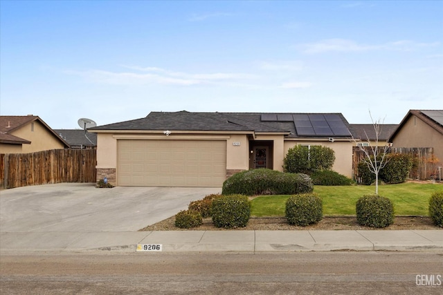 view of front facade featuring solar panels, a front lawn, an attached garage, and stucco siding