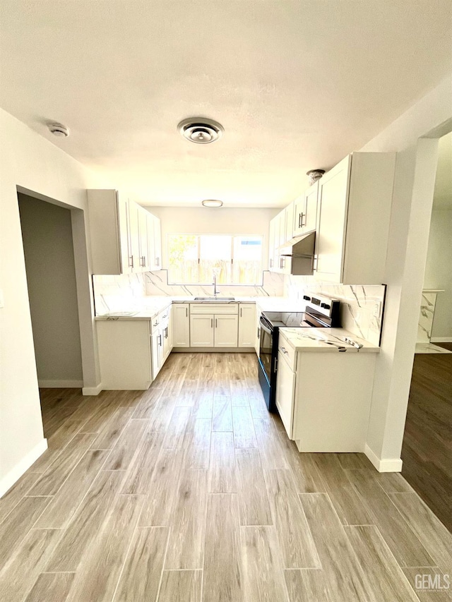 2301 Tangerine St, Bakersfield, CA 93306 - kitchen with range with electric stovetop, light wood-style floors, light countertops, and white cabinets