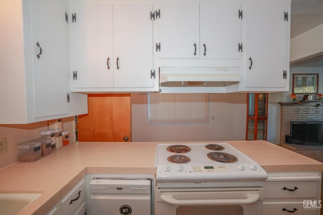 kitchen with decorative backsplash, white cabinetry, a fireplace, and white appliances