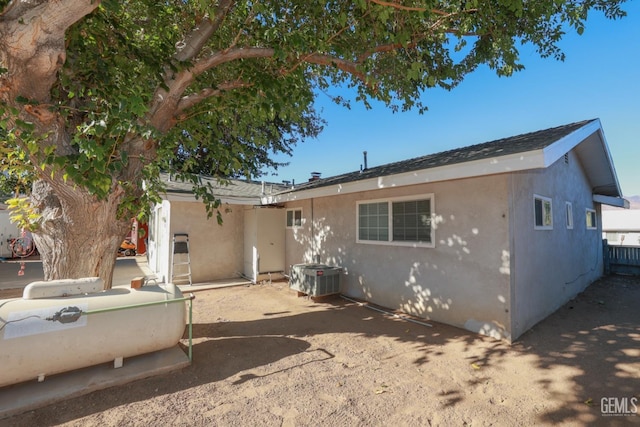 rear view of property with central AC