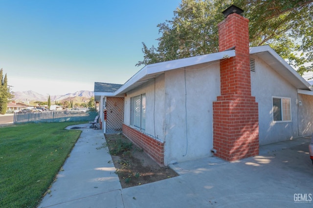 view of home's exterior with a mountain view and a yard