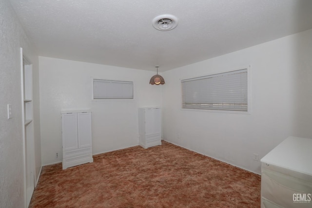 spare room with a textured ceiling and carpet floors