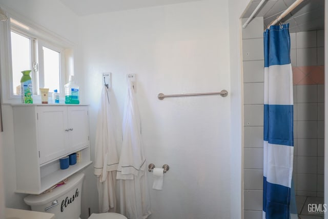 bathroom with curtained shower and toilet