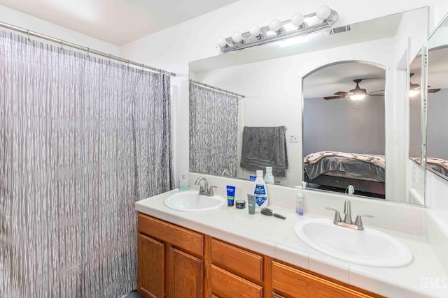 bathroom featuring vanity, curtained shower, and ceiling fan