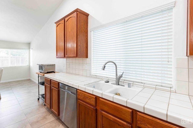 kitchen featuring tasteful backsplash, sink, tile countertops, and stainless steel dishwasher