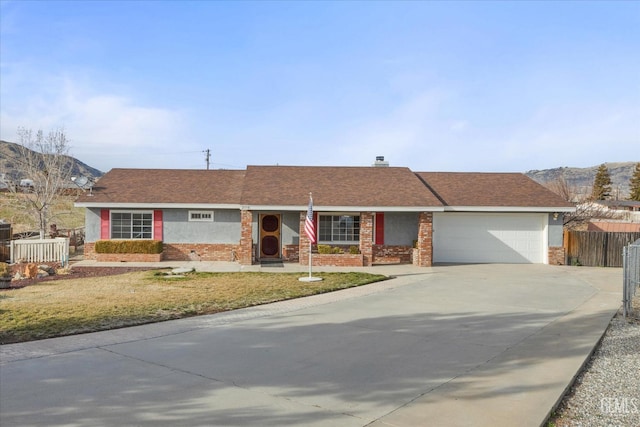 ranch-style home featuring driveway, roof with shingles, an attached garage, fence, and brick siding