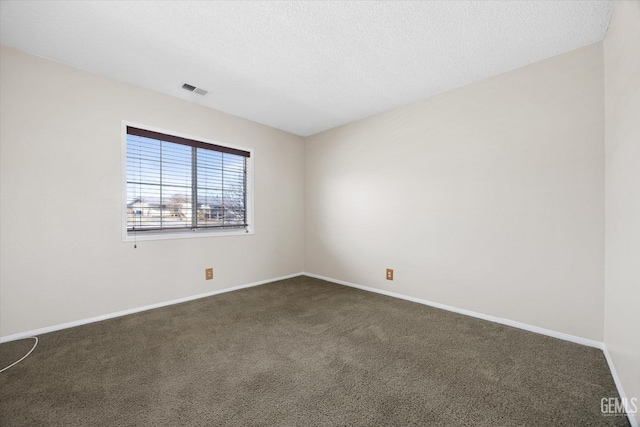 spare room featuring a textured ceiling, dark carpet, visible vents, and baseboards