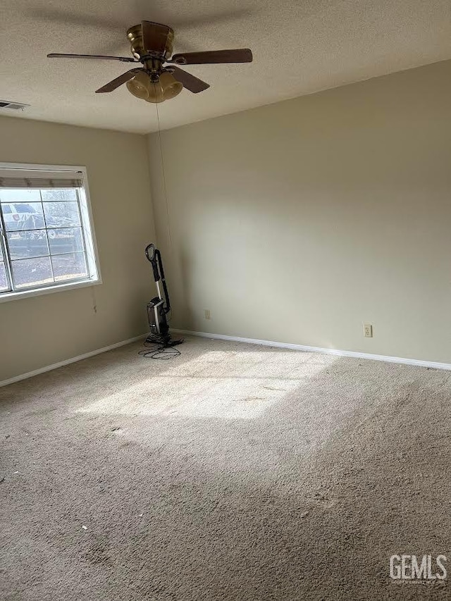 unfurnished room featuring ceiling fan, light colored carpet, and a textured ceiling