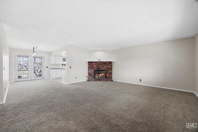 unfurnished living room featuring carpet floors, a brick fireplace, and baseboards