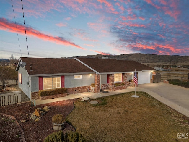 ranch-style house with a garage, stucco siding, driveway, and fence