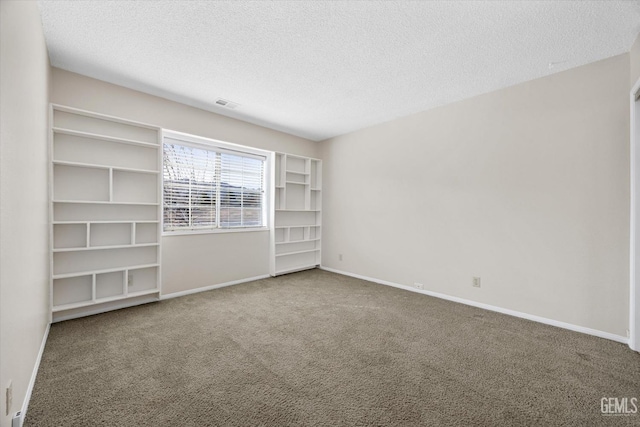 carpeted empty room with a textured ceiling, visible vents, and baseboards