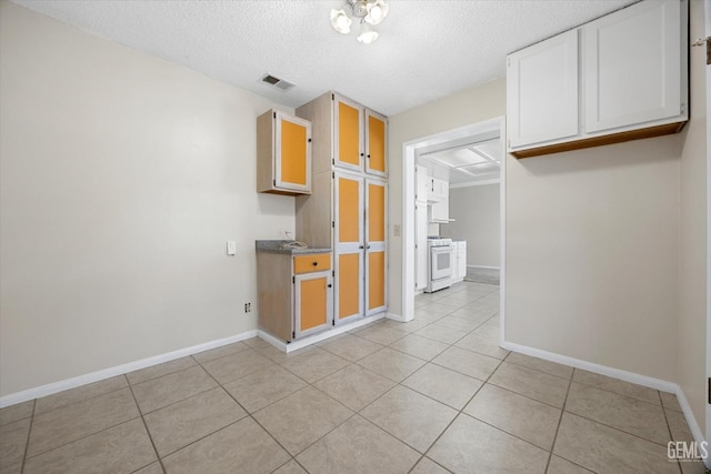 kitchen with white range with gas stovetop, visible vents, baseboards, and light tile patterned floors