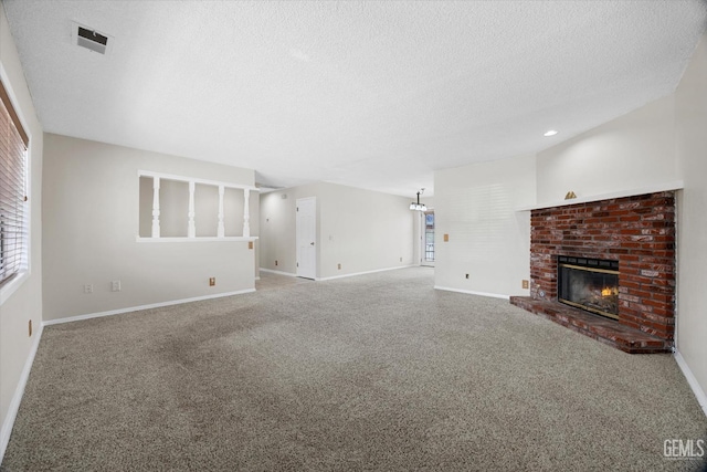 unfurnished living room featuring carpet floors, a fireplace, a textured ceiling, and baseboards