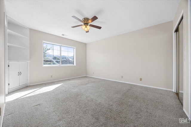 unfurnished bedroom with carpet floors, baseboards, visible vents, and a textured ceiling